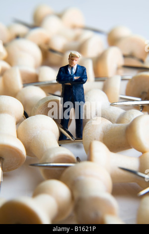 Geschäftsmann Figur stehend mit Reisszwecken Stockfoto