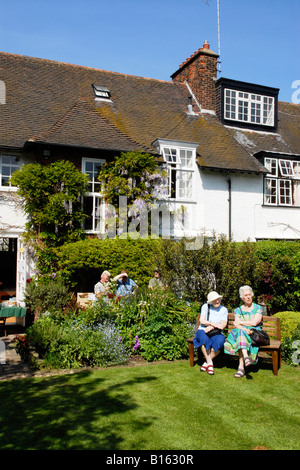 London Hampstead Garden Vorort National Gardens Scheme Open Suburban Garden Day for Charity zwei alte Damen genießen sommerliche Blumenvorführungen auf der Bank Stockfoto