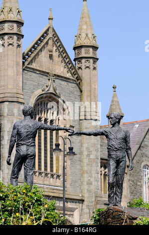 Hände über The Divide Statue mit Kirche hinter Stockfoto