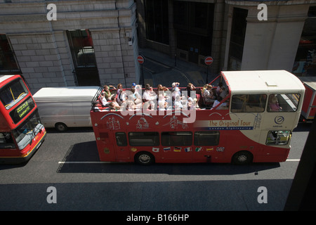 Ein offenen Bus voller Touristen geht durch eine neu gebaute Bürogebäude. Stockfoto