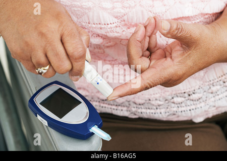 Senior-afroamerikanische Frau Blutzucker testen Stockfoto