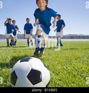 Multi-ethnischen Kinder Fußball spielen Stockfoto