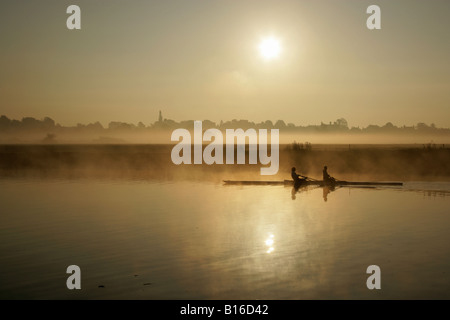 Von Chester, England. Sunrise-Ansicht der Ruderer auf dem Fluss Dee mit Chester Wiesen im Hintergrund. Stockfoto