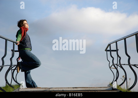 Frau gelehnt Treppe Geländer, die Sonne genießen Stockfoto