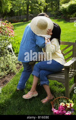 Hispanische paar versteckt sich hinter Strohhut Stockfoto