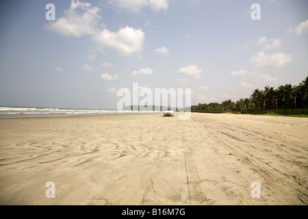 Ein Auto fährt auf Muzhappilangad fahren In Beach in der Nähe von Thalassery in Kerala. Es ist Indiens einzige Fahrt im Strand. Stockfoto