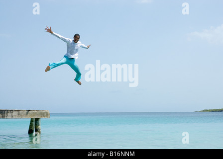 Hispanic Mann springt aus dock Stockfoto