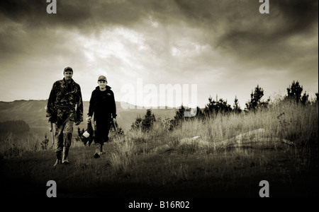 Vater und Sohn auf der Jagd in dem Land mit Hund Stockfoto