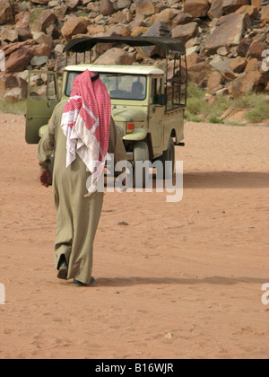 Ein Beduinen-Mann zu Fuß in Richtung Jeep in die Wüste Wadi Rum, Jordanien Stockfoto