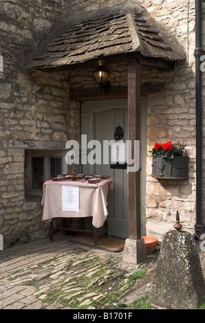 Haus in Castle Combe Verkauf von Kuchen vor der Haustür, The Cotswold, Wiltshire, England, Großbritannien Stockfoto