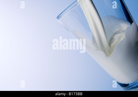 Milch spritzt aus Glas Stockfoto