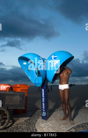 Man spricht in einem öffentlichen Telefon Rio De Janeiro Brasilien 28 02 06 Stockfoto