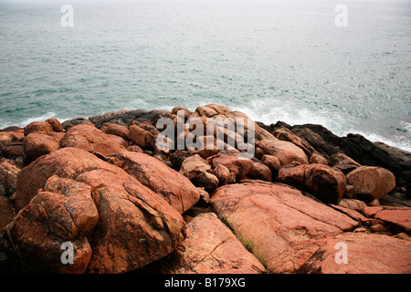 Roten Felsen am Strand von Kovalam, Kerala, Indien Stockfoto