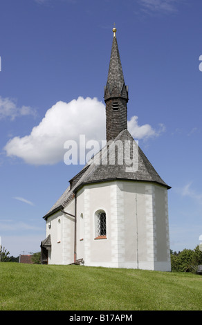 Kleine Kapelle auf einem grünen grasbewachsenen Hügel in Bayern, Deutschland Stockfoto