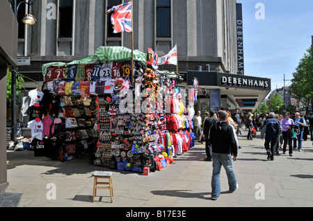 London West End Oxford Street Einkaufsviertel Souvenir Verkaufsstände Einkaufen Käufer in breitem Asphalt Debenhams Kaufhaus jenseits von England Großbritannien Stockfoto