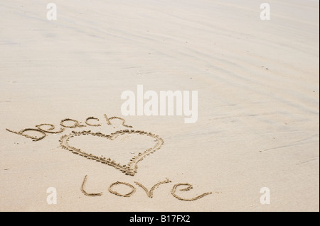 Herzform und Worte "Beach Love" an einem Strand in den Sand gezeichnet. UK Stockfoto