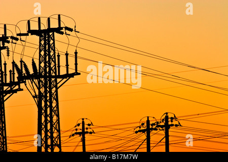 Energie/Strom mit hoher Spannung Sendemasten Silhouette bei Sonnenuntergang. Stockfoto