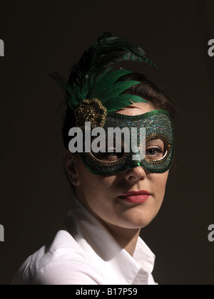 Rätselhafte junge Frau im grünen Maske vor schwarzem Hintergrund Stockfoto