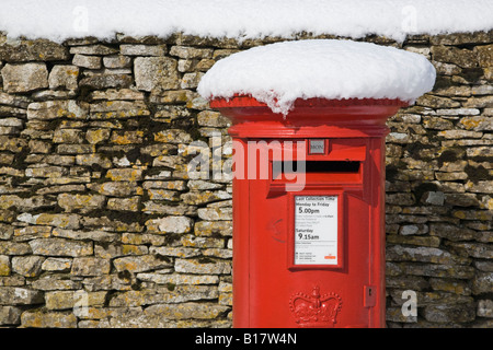 rot Royal Mail-Briefkasten im Schnee durch Trockenmauer Oxfordshire England UK Stockfoto