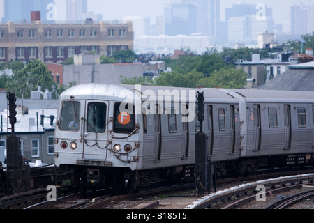 Ein New Yorker MTA F-Zug klettert gegenüber Smith / 9. Straße station in Brooklyn, New York an einem heißen und trüben Junitag. Stockfoto