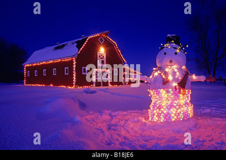 Schneemann vor der roten Scheune, in der Nähe von Oakbank, Manitoba, Kanada Stockfoto