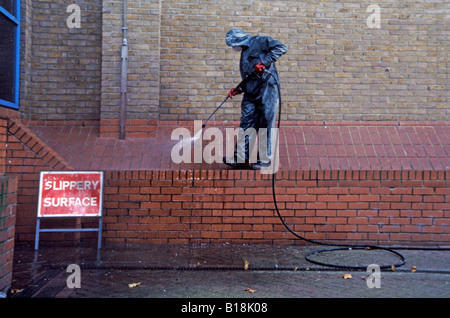 Des Rates Arbeiter Spray Reinigung von Taubenkot vom Gebäude in Greenwich, London, England, UK Stockfoto