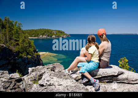 Junge Mutter und Tochter genießen Sie Blick auf die Grotte entlang Bruce Trail, Bruce Halbinsel-Nationalpark, in der Nähe von Tobermory, Ontario, C Stockfoto