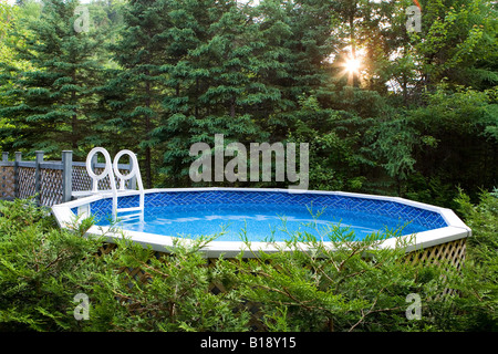 oberirdisch Swimming Pool umgeben von immergrünen Bäumen, Val David, Quebec, Kanada. Stockfoto