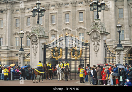 Großbritannien London Massen Linie Bürgersteig Fuß berittene Polizei durch Tore Buckingham Palace warten wechselnde Wachablösung Stockfoto