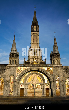 FRANKREICH, LOURDES. Morgen Sonnenstrahlen fallen auf die Kirche in der Wallfahrtskirche in Lourdes, Frankreich Stockfoto