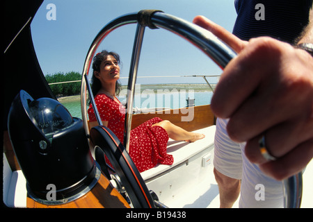 Eine hübsche Brünette Frau in einem roten Kleid genießt ein Sommer Boot fahren auf den Florida Keys (Modell freigegeben) Stockfoto