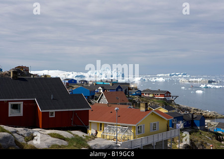 Ilulissat, Grönland UNESCO World Heritage Site Eisfjord. Blick über die Dächer der Wohngegend der Stadt, die Bucht vollgepackt mit riesigen Eisbergen vorbei. Stockfoto