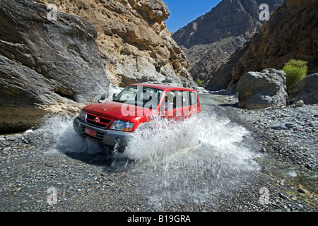 Oman, westlichen Hajar-Gebirge, Wadi Bani Awf. Ein vier-Rad-Antrieb macht es über weiteres Wadi Flussüberquerung. Stockfoto