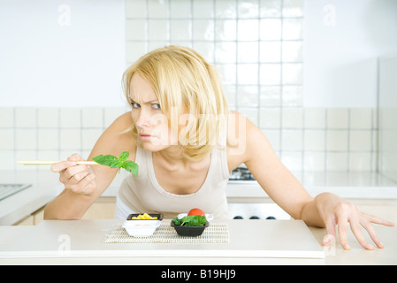 Frau beugte sich über Essen, Blick in die Kamera bedrohlich Stockfoto