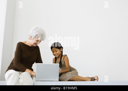 Ältere Frau mit Laptop mit kleinen Mädchen Stockfoto