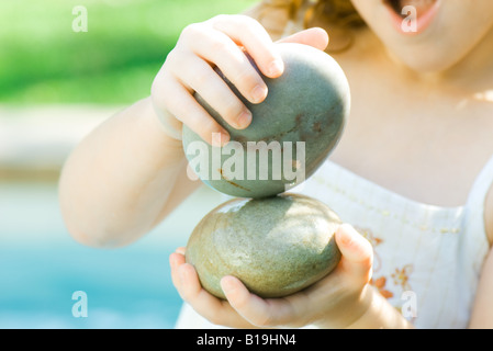 Kind spielt mit Steinen Stockfoto