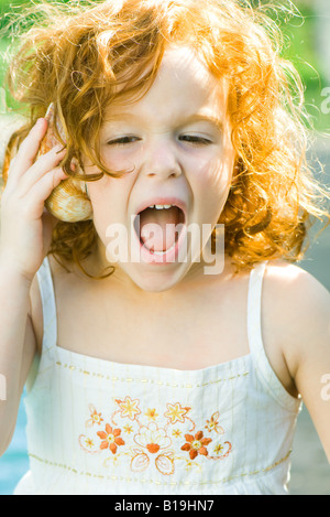 Mädchen hören, Muschel, schreien Stockfoto