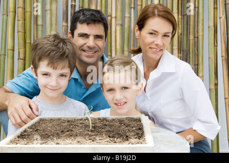 Familie vergossen zusammen, lächelnd in die Kamera, Sämling im Vordergrund Stockfoto