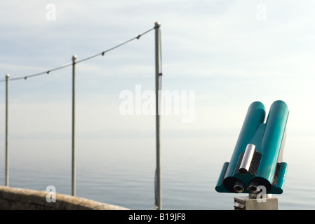 Münz-Fernglas am Wasserrand, Polen mit Lichtern im Hintergrund Stockfoto