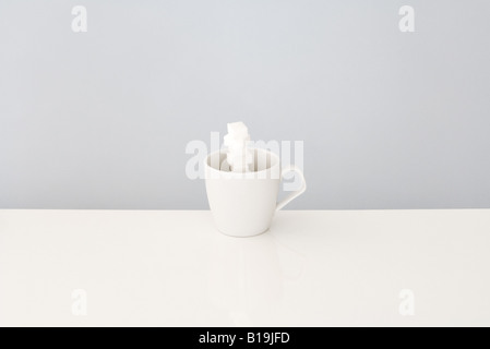 Zuckerwürfel gestapelt in Kaffeetasse Stockfoto