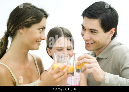 Familie machen einen Toast mit Orangensaft, alle Lächeln auf den Lippen Stockfoto