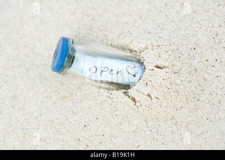 Eine Flaschenpost, halb im Sand begraben Stockfoto