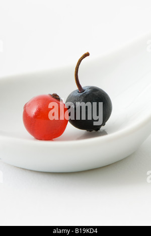 Red currant and black currant on spoon, close-up Stockfoto
