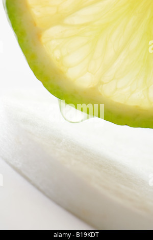 Saftige Limetten in Scheiben schneiden und Baumwolle Kosmetik Pad, close-up Stockfoto