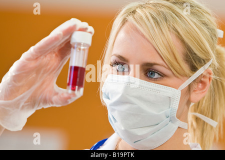 Eine junge Ärztin oder Krankenschwester Blick auf eine Blutprobe Stockfoto