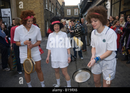 Konkurrenten in der Great Spitalfields Pancake Race-Praxis die Pfannkuchen vor dem Rennen zu werfen. Stockfoto