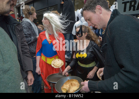 Konkurrenten in der Great Spitalfields Pancake Race-Praxis die Pfannkuchen vor dem Rennen zu werfen. Stockfoto