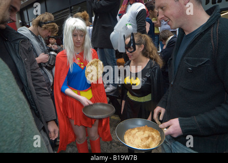 Konkurrenten in der Great Spitalfields Pancake Race-Praxis die Pfannkuchen vor dem Rennen zu werfen. Stockfoto