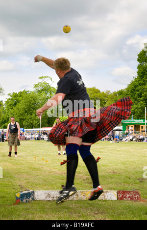 Tragen Tartan ein Kilted Konkurrent, Putting the Stone, Strathmore Scottish Games, Schottland Großbritannien. Starke Mann schwere sportliche Veranstaltungen in Highland Gathering. Stockfoto