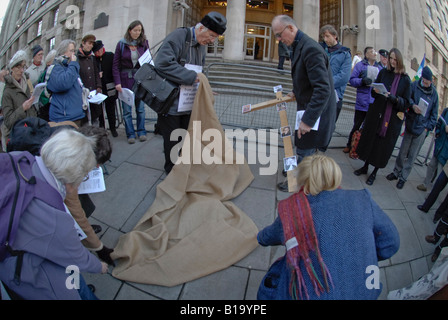 Ein hölzernes Kreuz wurde gelegt auf Sackleinen und bestreut mit Asche außerhalb des Verteidigungsministeriums in London Stockfoto